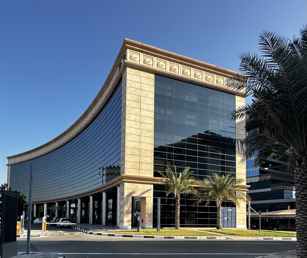 DAFZA office building in Dubai with curved stone-clad facade, cornice detailing and glazed curtain wall