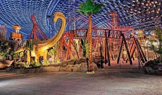 IMG Worlds of Adventure Lost Valley with full-scale dinosaur, roller coaster track and the complex engineered ceiling grid