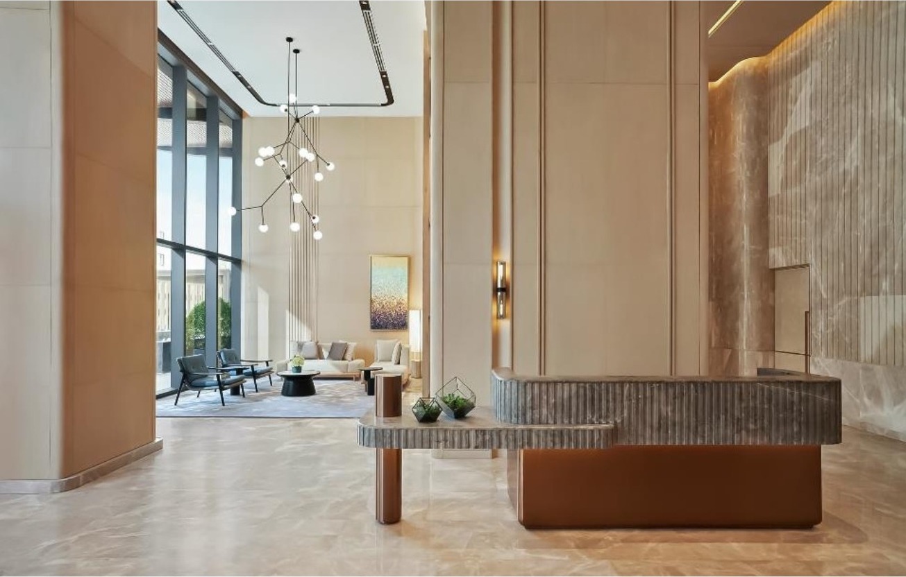 Grand Marina branded residence lobby with reception desk, marble floor and full-height glazing over the Saigon River